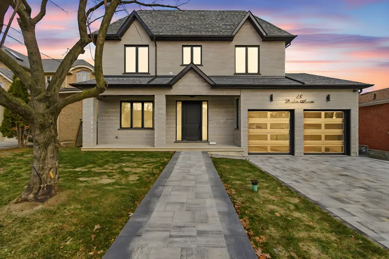 Modern Toronto home, daytime photo and the same photo edited to dusk with the windows and garage lit — dusk version