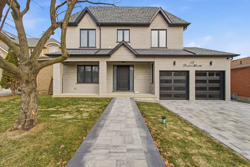 Modern Toronto home, daytime photo and the same photo edited to dusk with the windows and garage lit — day version